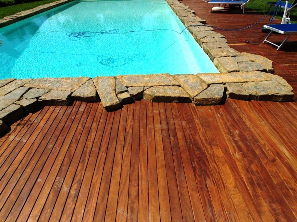 Particolare bordo piscina realizzato da Artwood in iroko e pietre
