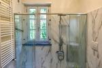 Una soluzione bella e sicura per inglobare la finestra nella doccia