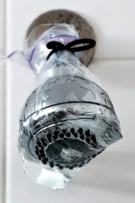 Eliminare il calcare dal soffione della doccia con un sacchetto pieno di aceto, da dyncrafts.com
