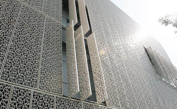 Edificio con facciata in pannelli grigliati di ceramica policroma di Ceipo