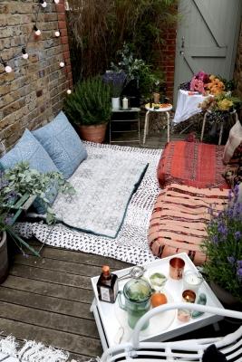 Balcone arredato con tappeti e cuscini, da fashionmenow.co.uk