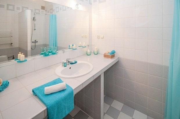 Particolari e piastrelle bianche per illuminare il bagno grigio