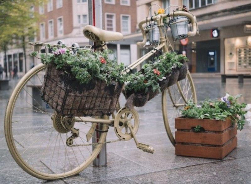 Cassette riciclate, usate congiuntamente ad una bici riciclata, per arredo floreale da spazio esterno, pubblico o privato