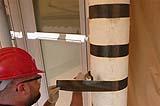 Applicazione di fasciature di fibre di carbonio su una colonna di pietra, by IDES