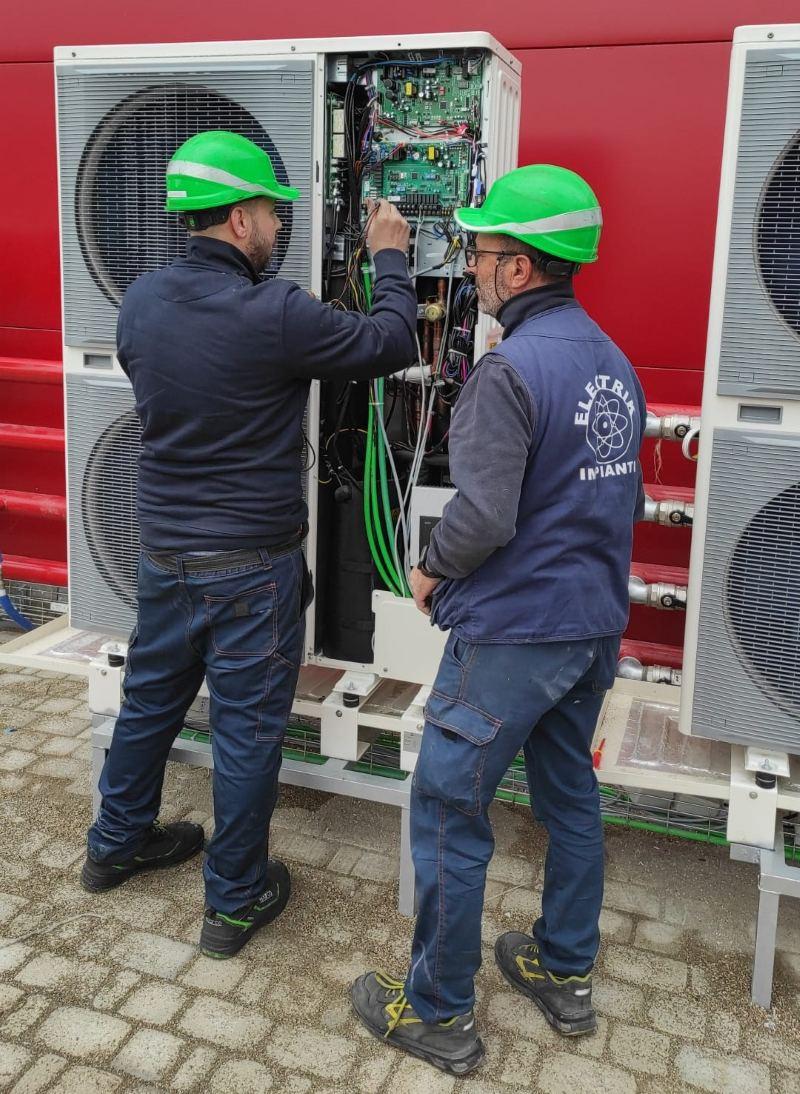 Operai a lavoro su un motore di un condizionatore 