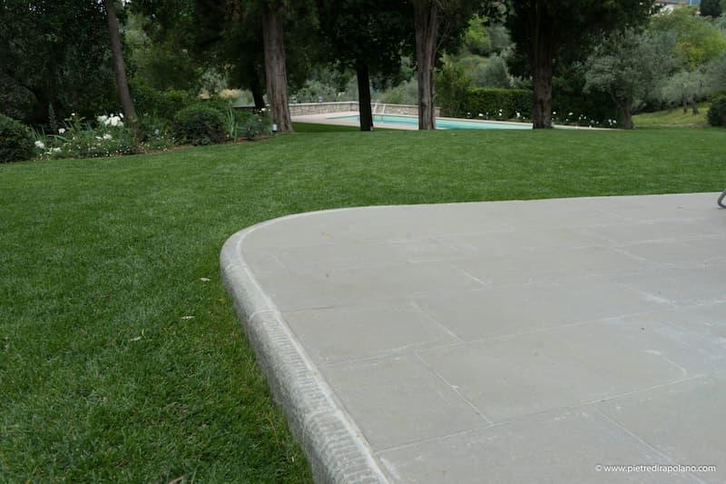 Pavimento in pietra per piscina con bordo curvo e posa regolare.