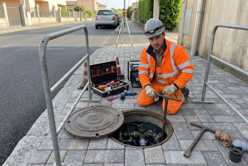 Operaio al lavoro su tombino