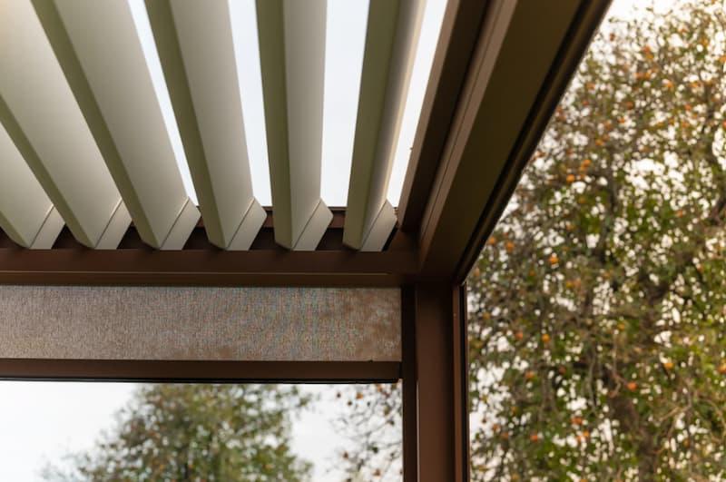 Pergola bioclimatica con lamelle orientabili per ombreggiare il balcone senza impedire il ricambio d’aria.
