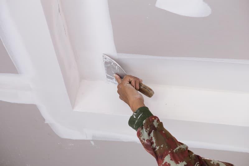 Pittura e manutenzione di un controsoffitto microforato - foto getty images
